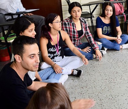 estudiantes sentados en el suelo.