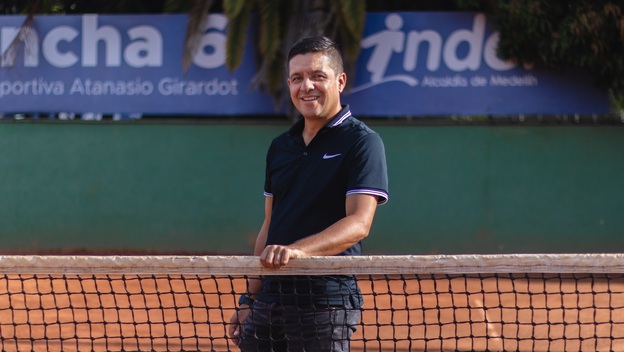 Esteban Jiménez, egresado UdeA, es juez de tenis y tiene su mano en la malla de la cancha de tenis de la Liga Antioqueña de Tenis