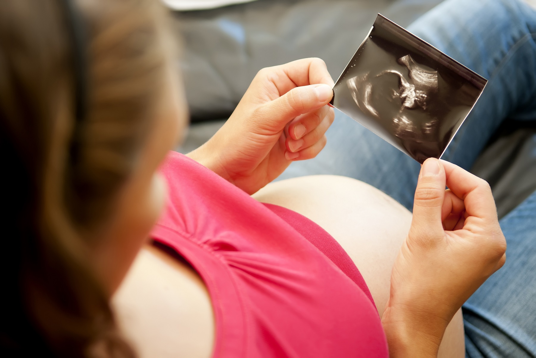 Mujer embarazada sosteniendo la ecografía de su bebé