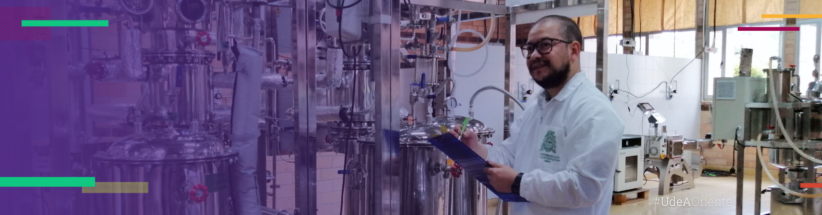 Un técnico de laboratorio sostiene una planilla frente a equipos de procesamiento de alimentos