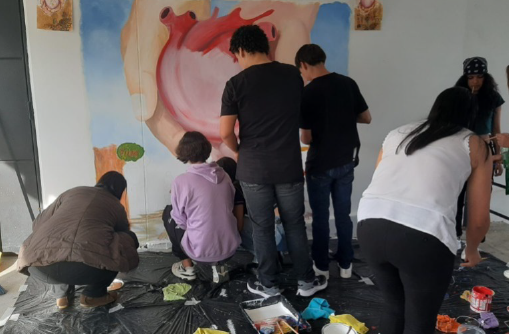 Tres íconos de siluetas de personas y una mano señalando al ícono de la mitad.